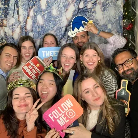 Group of guests posing with props at a corporate photo booth