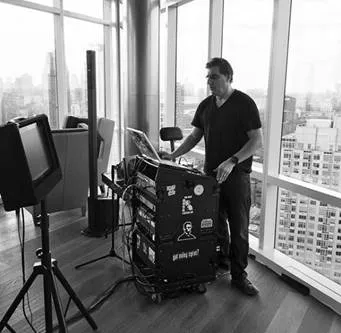 David Swirsky at his DJ and karaoke rig by a floor-to-ceiling NYC window