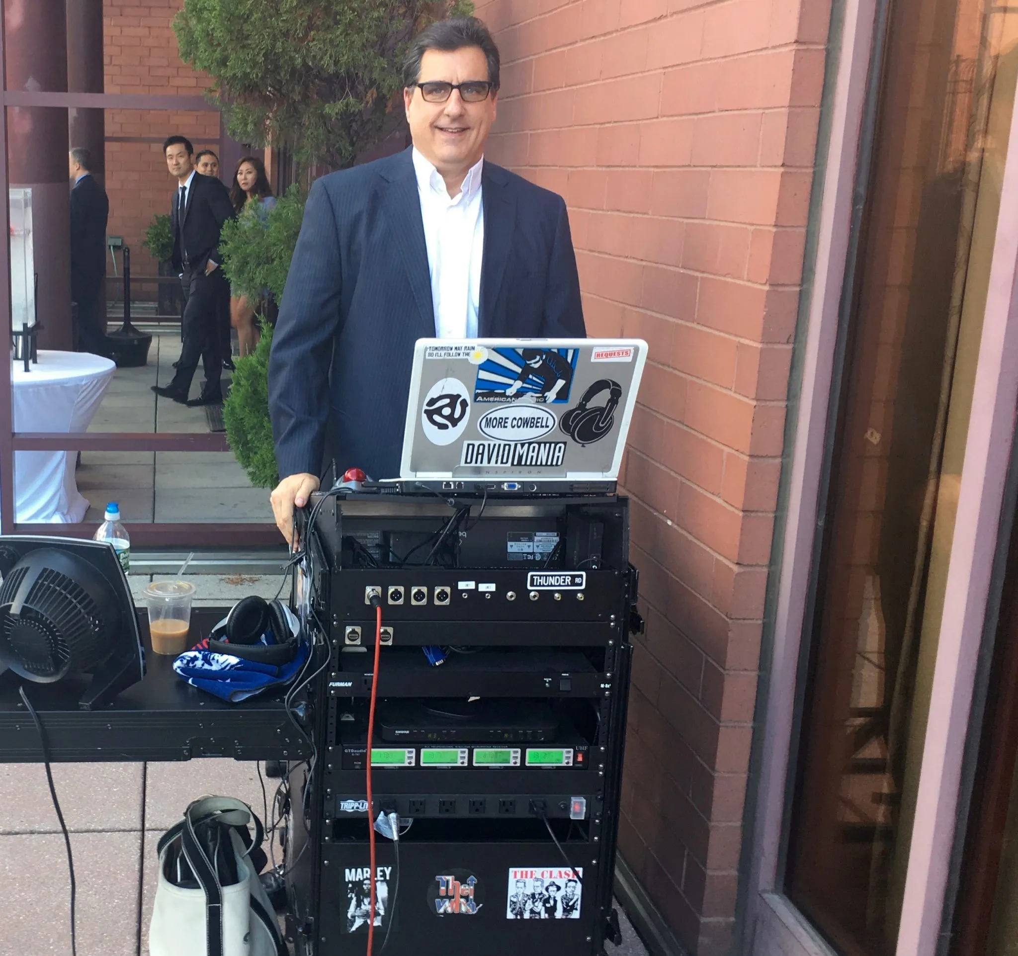 DJ David Swirsky smiling behind his DJ rig at a wedding